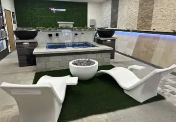Lounge chairs and firepit facing a water feature in the Gorman Baymeadoes pool showroom