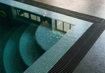 Rounded stairs in the corner of a back yard swimming pool